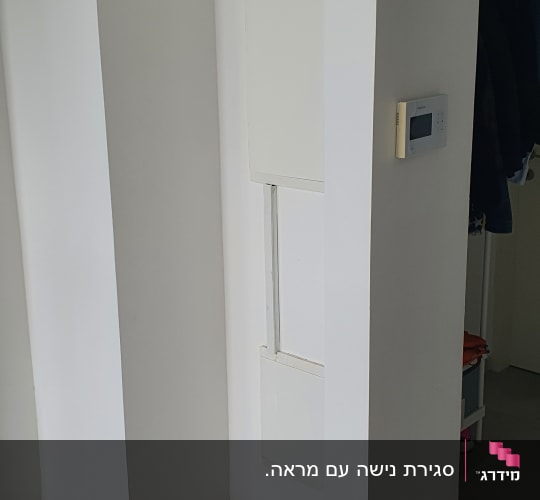 קיר לבן עם לוח חשמל ותרמוסטט